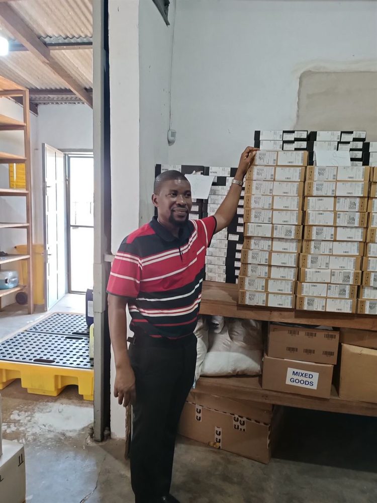 Un membre de l’équipe Hankaka à côté de matériel informatique préparé et étiqueté pour le déploiement dans l’entrepôt sécurisé d’Accra
